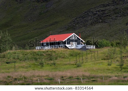 black house with red roof and white trim in Iceland