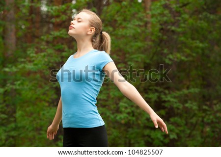 Young beautiful woman doing yoga meditation in forest outdoors