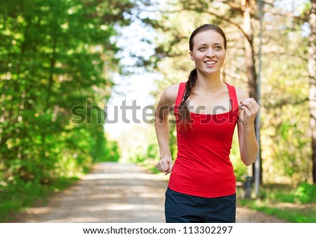 Young beautiful athlete woman jogging outdoors in park