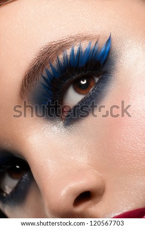 Close-up shot of beautiful female eye with bright fashion makeup. Woman eye with blue false eyelashes