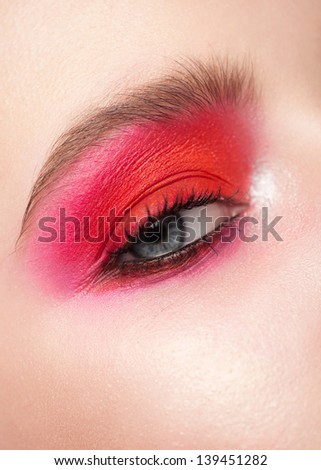 Close-up of beautiful woman blue eye with bright pink makeup