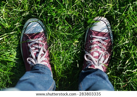 Image of male feet in boots on green grass outdoors