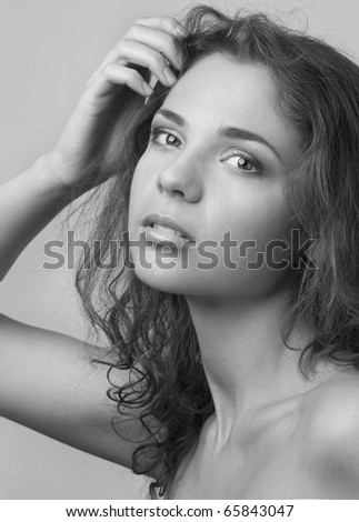 Portrait of the beautiful young woman with curly hairs and natural make-up (black and white)