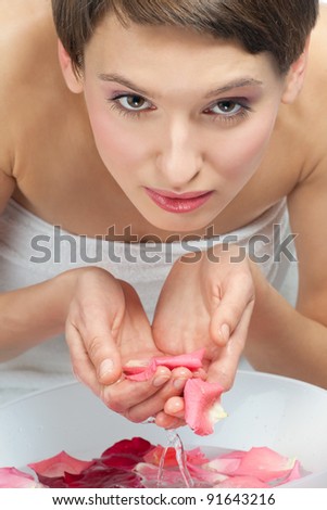 Portrait of a pretty young woman washing her face with water