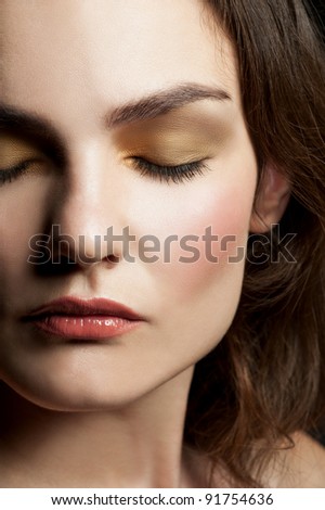 Close-up portrait of young beautiful woman with closed eyes with stylish make-up