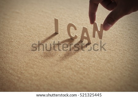 I CAN wood word on compressed board,cork board with human's finger at N letter 商業照片 © 