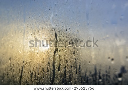 Mist and raindrops on glass pane after a night of rain