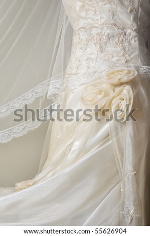 Close-up of white wedding gown on plain background