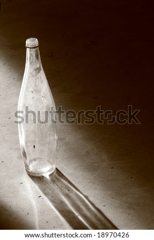 old empty bottle with shadow, in sepia