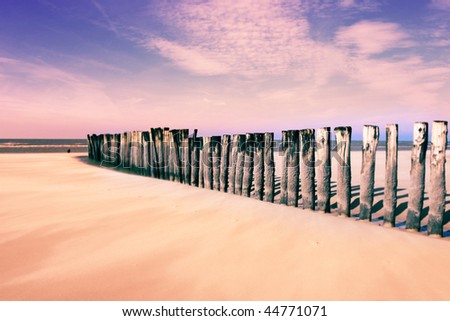wave-breaking wooden poles, on the beach, tilt-shift effect