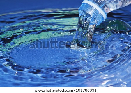 The stream of water flowing from the bottle.