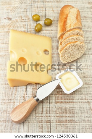 Breakfast of cheese bread and olives. On the board texture.