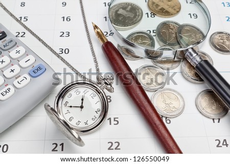 Office supplies and pocket watches. Against the background of the calendar.