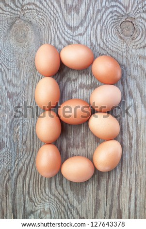 A letter b from the eggs for Easter. On a wooden texture.