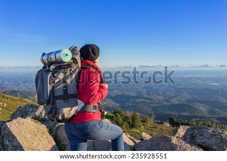Girl tourist with a backpack on a mountain top. In a campaign in Portugal.