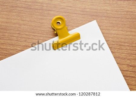 Memo pad and paper clip on wooden desk