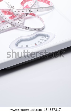 Close-up of a tape measure and Bathroom scale