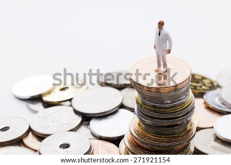 Doctor of the doll on top of the stacked coins