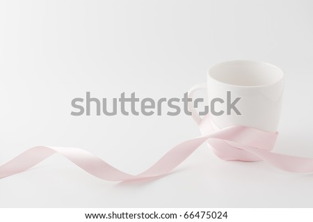 Pink ribbon wrapped around the cup isolated on white background