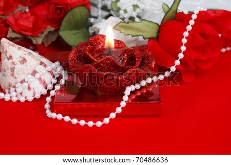 Rose Spa Therapy with Candle, Flowers, Seashell and Pearl Necklace on a Bright Red Background