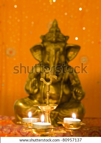 Beautifully lit lamps and sacred religious symbol OM around Hindu Lord Ganesh