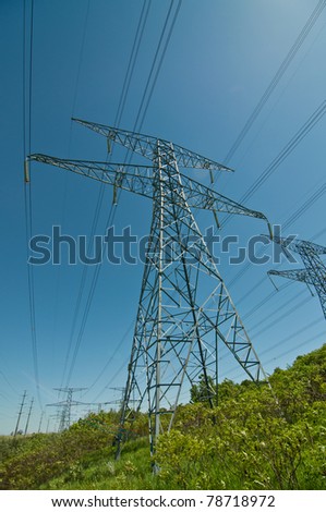 A long line of electrical transmission towers carrying high voltage lines.
