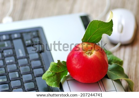 Red apple on keyboard  and mouse on table