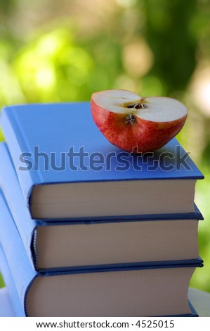 Half of the apple on books.