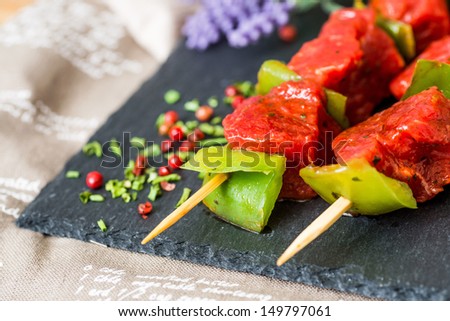 tasty beef steak kabobs with vegetables on a slate plate