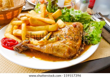 Chicken with sauce and golden French fries potatoes