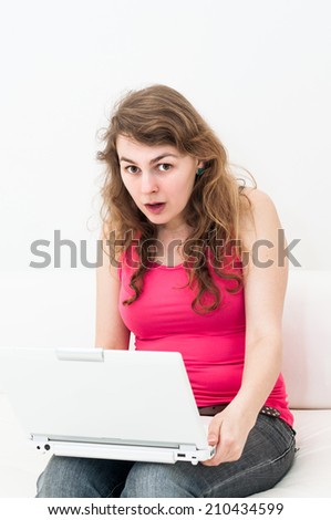 young woman sitting with laptop on couch
