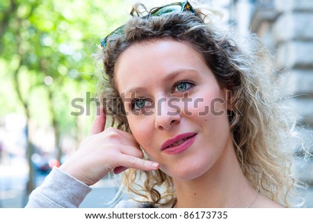 Outdoor portrait young woman talk on a cellular telephone