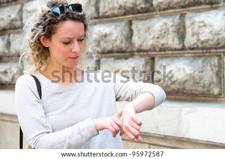 beautiful young woman checking the time on her wrist watch