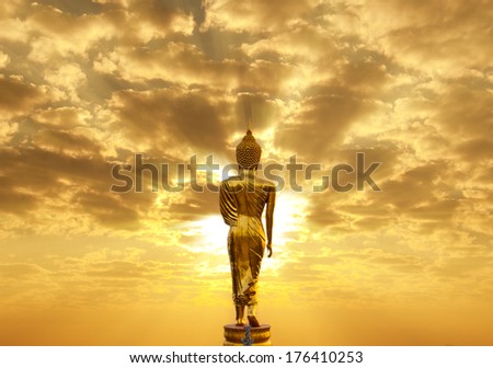 Golden Buddha statue in Wat Phra That Khao Noi, Nan Province, Thailand facing sun light