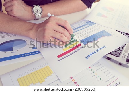 man working on paper chart, performance reporting, business concept