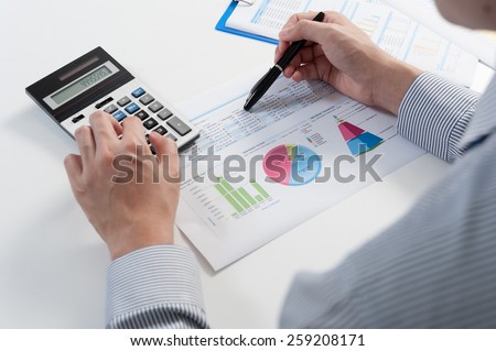 Businessman analyzing report, business performance concept