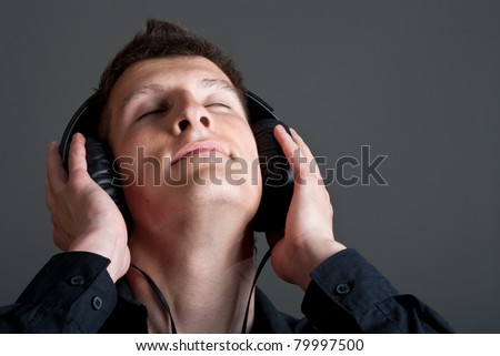 Young male person listening to music with headphones