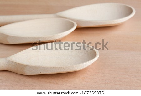 Three wooden spoons on a kitchen chopping board