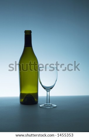 Wine bottle and glass, both are empty. Backlight with small amount of fill.