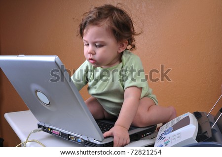 Baby concentrating hard, working on her computer laptop. Concept of baby secretary.