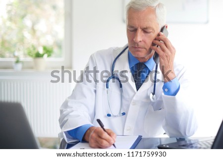 Similar – Image, Stock Photo Doctor making a phone call. Hospital staff working at night duty. Woman wearing uniform, cap and face mask to prevent virus infection