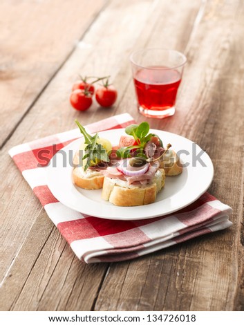 Turkey and parma ham canapes (sandwiches) with tomato, onion, caper and raspberry drink