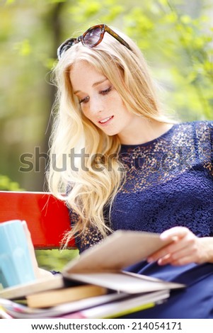 Portrait of attractive female student sitting at campus area. Student life.