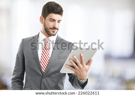 Portrait of young broker holding digital tablet in his hands.