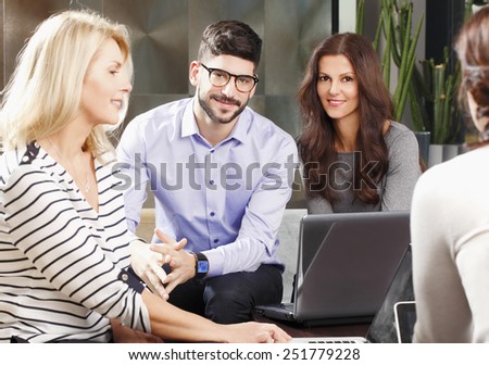 Business women and businessman sitting at office in front of computer and consulting from business project.