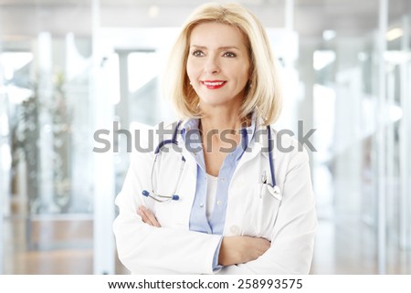 Portrait of smiling female doctor close-up with arms crossed.