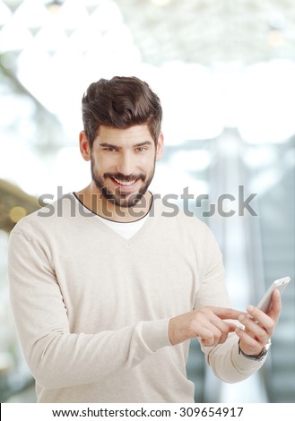 Portrait of young businessman standing at office and holding hands handy while typing text.