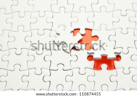 Plain white jigsaw puzzle, on orange background.