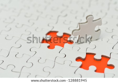 Plain white jigsaw puzzle, on Orange background.