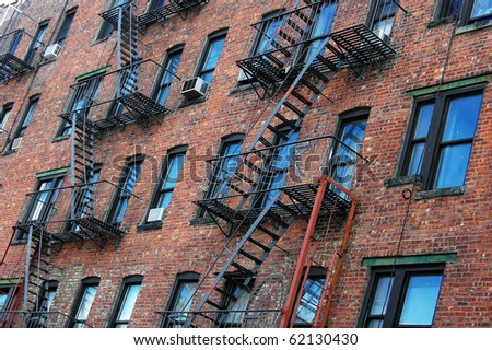 The outside wall of an apartment block featuring fire escapes in New York City.